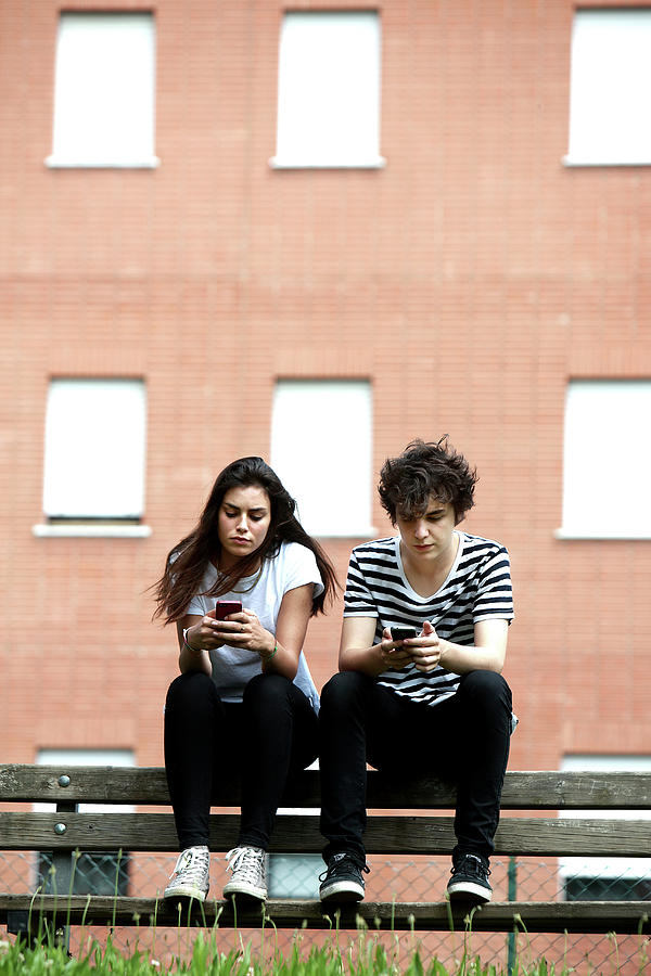 Human Photograph - Teenage Couple Using Smart Phones by Mauro Fermariello