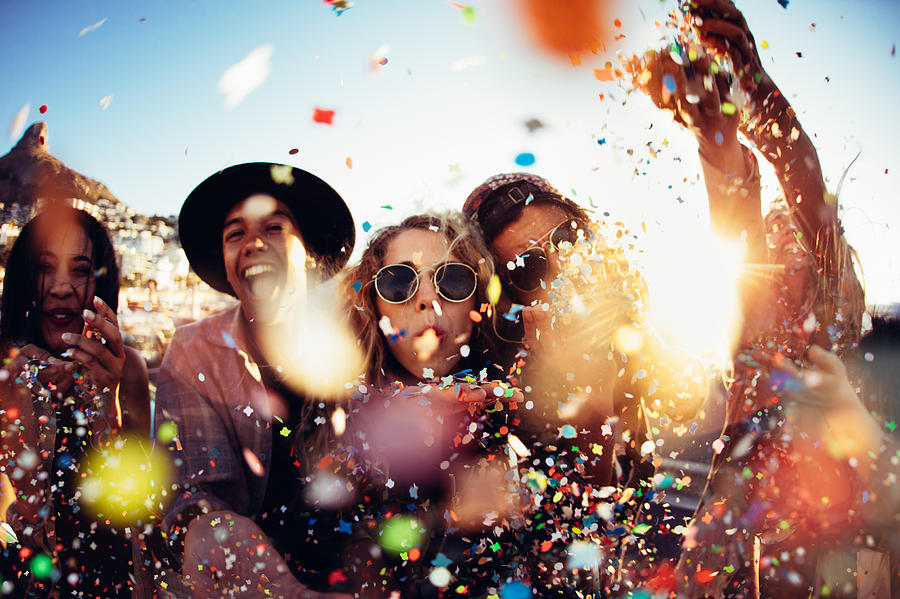 Teenager hipster friends partying by blowing colorful confetti from hands Photograph by Wundervisuals