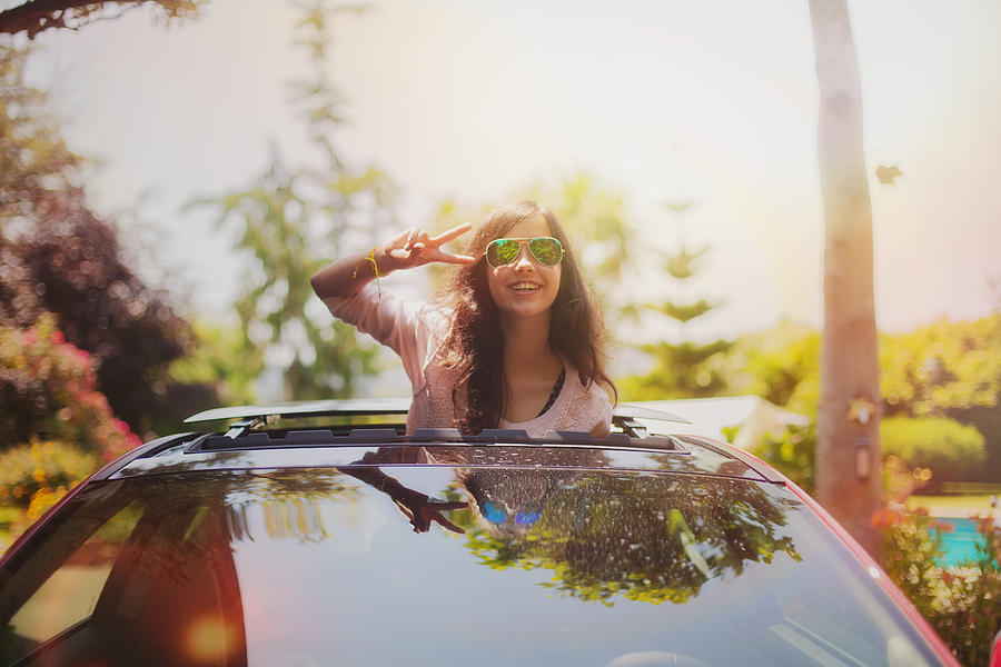 Teenager in sun roof Photograph by Carol Yepes