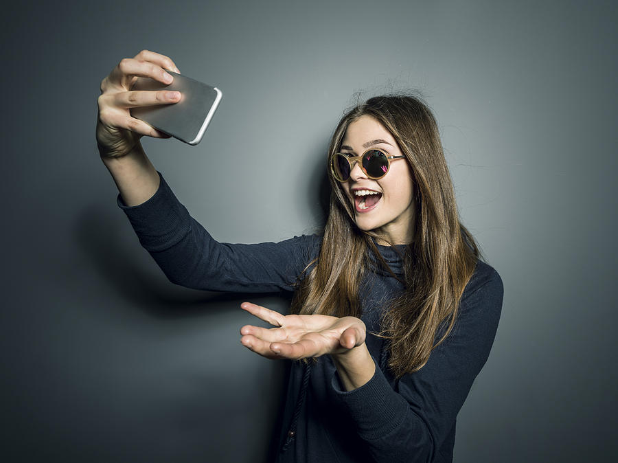Teenager Mädchen macht Selfies mit Handy Photograph by Martin Steinthaler