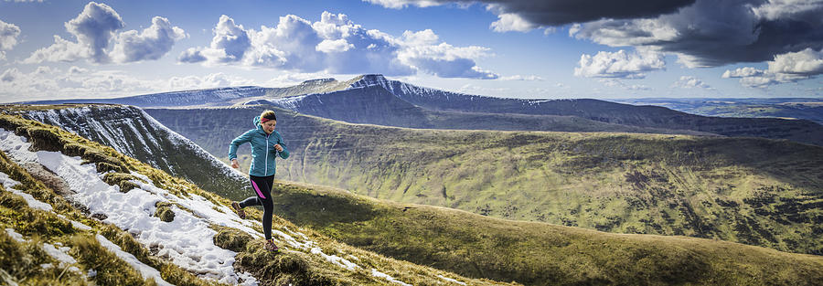 Teenager trail running along mountain path Brecon Beacons panorama Wales Photograph by fotoVoyager