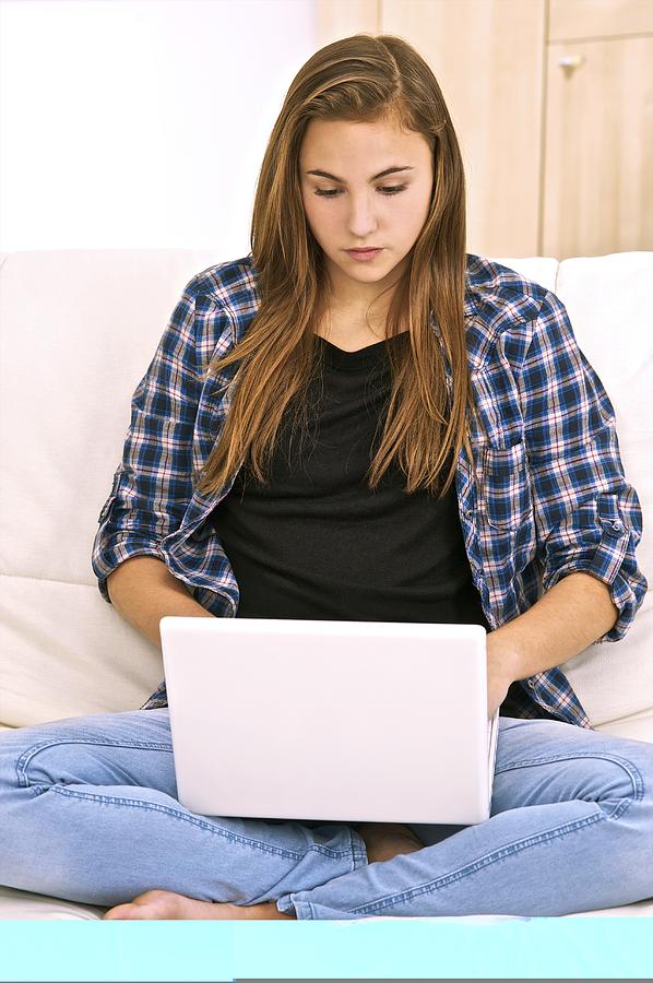 Teenager using a laptop computer Photograph by Science Photo Library