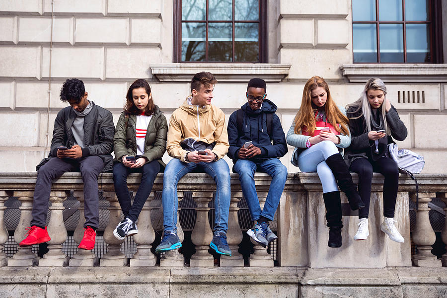 Teenagers students using smartphone on a school break Photograph by LeoPatrizi