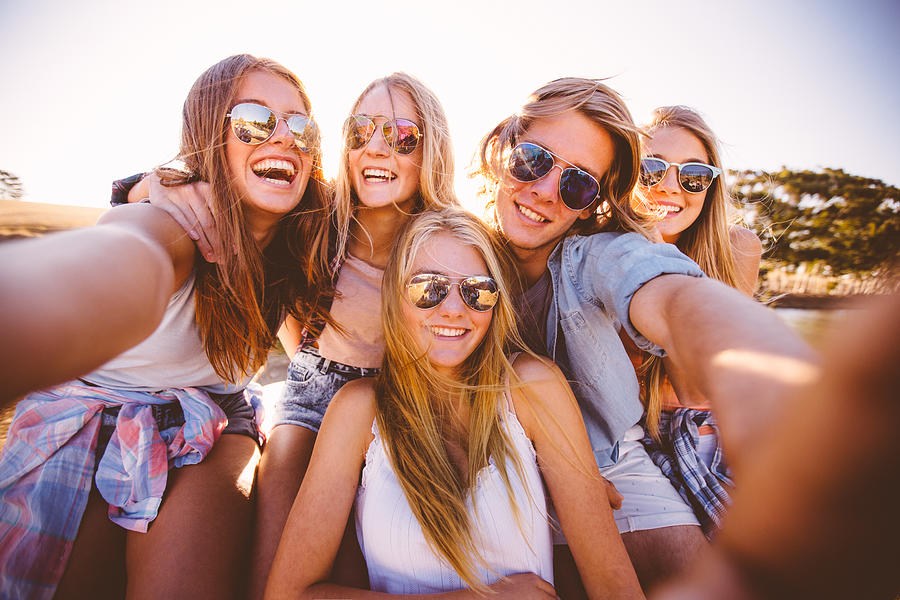 Teens in shades taking a group selfie outdoors Photograph by Wundervisuals