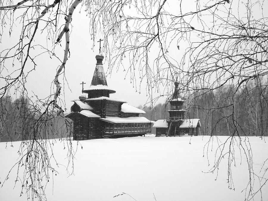 The ancient wooden temple in snow is visible through branches of trees ...