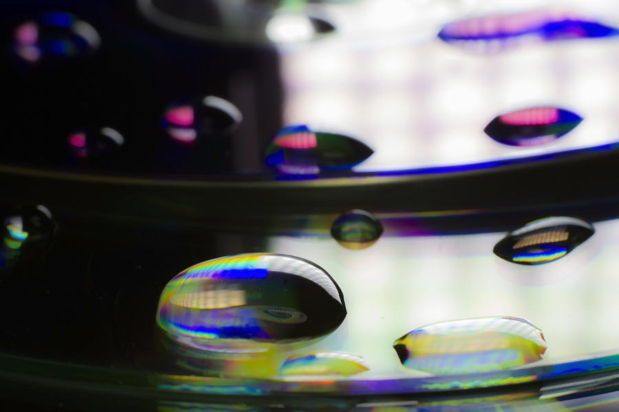 The macro world of water drops on a laser disk Photograph by Sven Brogren