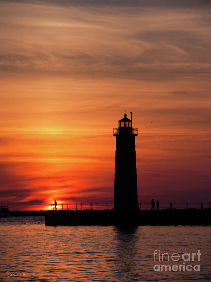 The Muskegon Lighthouse an a lone man fishing Photograph by John Harmon
