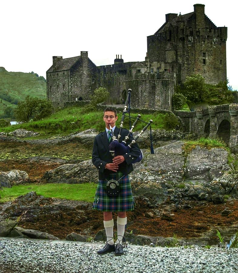 The Piper at Eilean Donan Castle Photograph by Joan-Violet Stretch