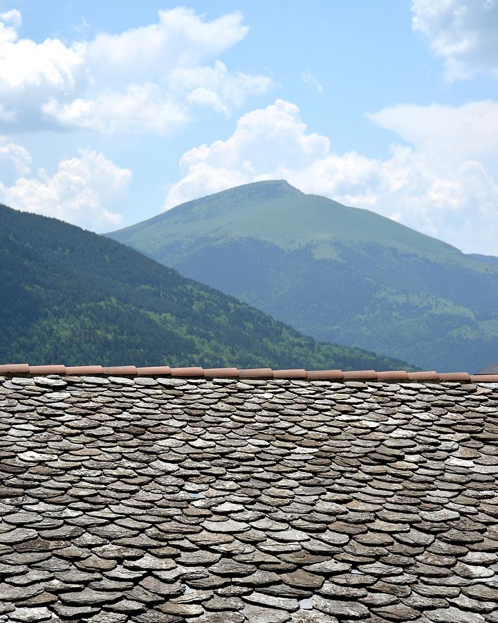 The Pyrenees mountains over the rooftops of Vic Photograph by Toby McGuire