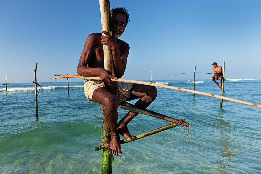 The Stilt Fishermen At Work, Sri Lanka Photograph by Hadynyah