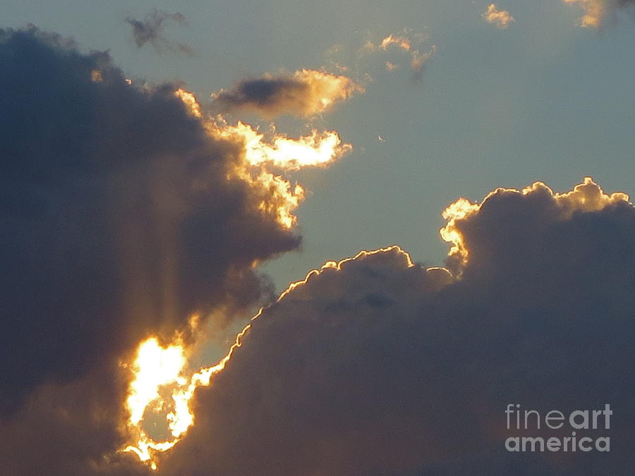 The Suns golden rays piercing through a cloud at Sunset  Photograph by Robert Birkenes
