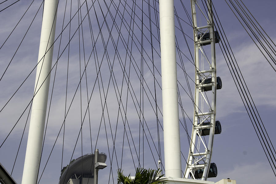 The top section of the Marina Bay Sands as seen through the spokes of the Singapore Flyer Photograph by Ashish Agarwal