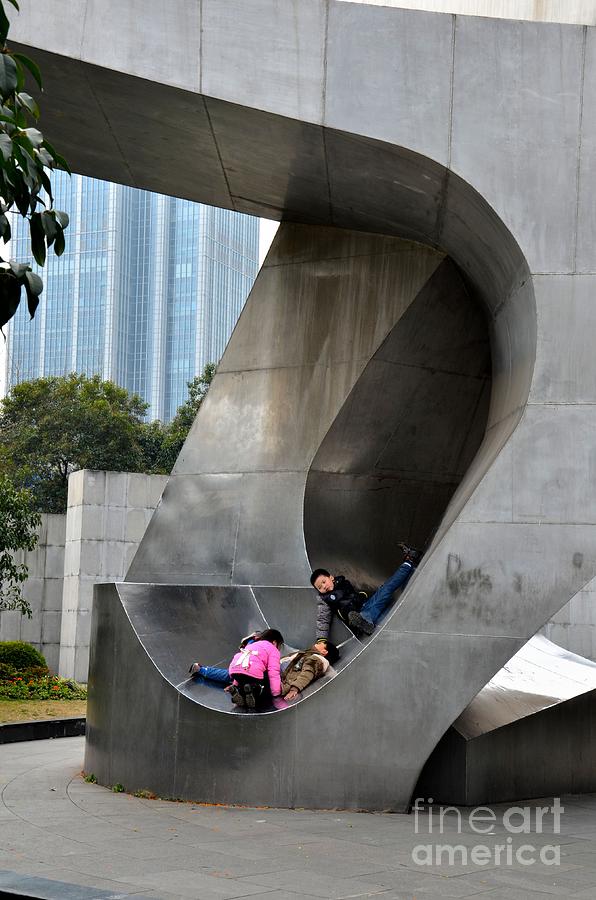 Three children play on large metal sculpture Shanghai China Photograph by Imran Ahmed