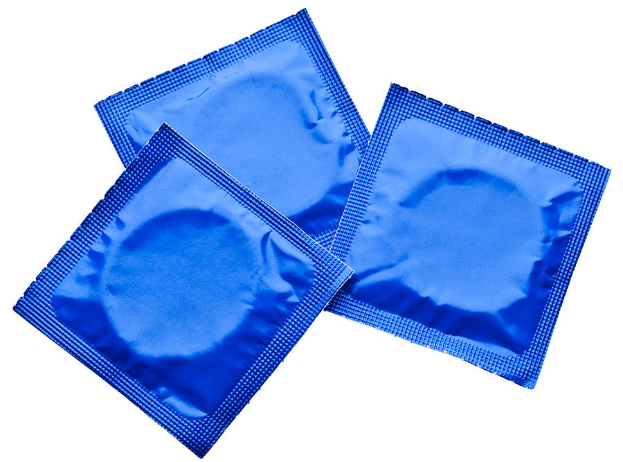 Three condoms in wrappers Photograph by Creative Crop