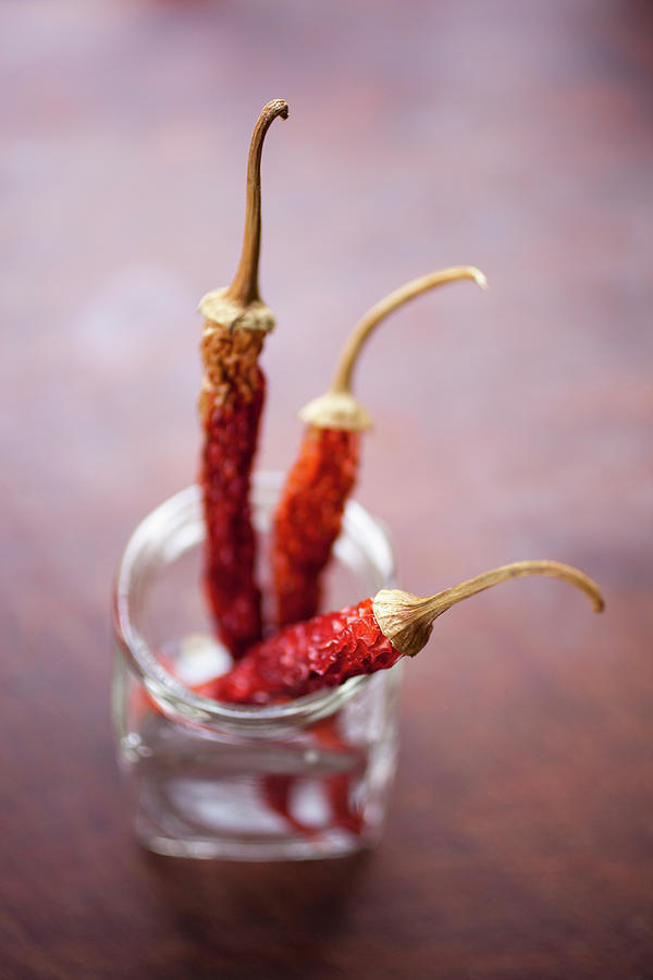 Three Dried Chilies In A Glass Jar Photograph by Tobias Titz