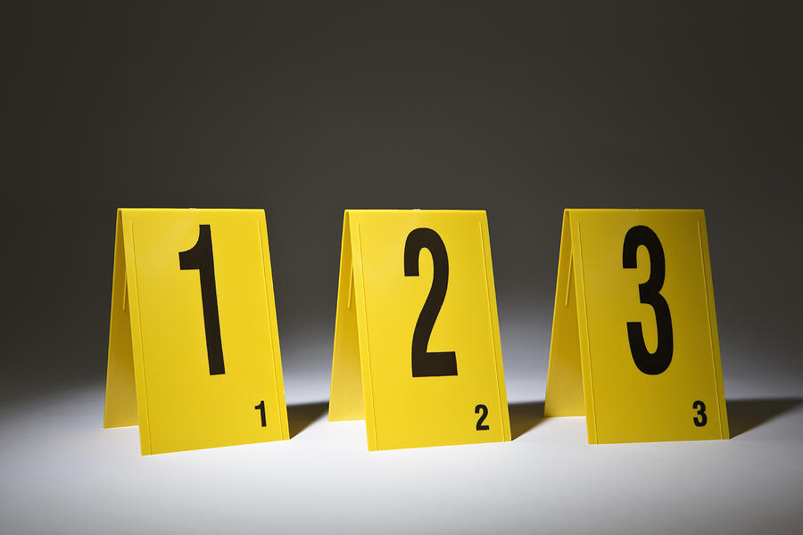 Three evidence markers arranged in a row in numerical order Photograph by Caspar Benson