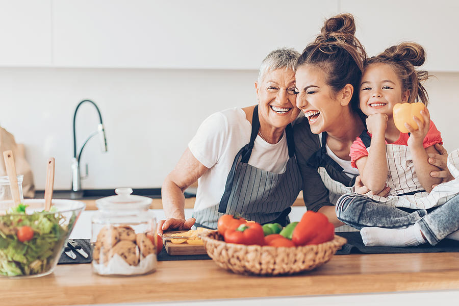 Three generations women laughing in the kitchen Photograph by Petar Chernaev