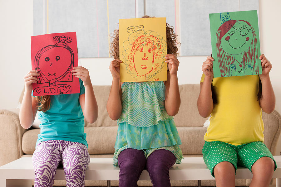 Three girls holding pictures over faces Photograph by Rob Lewine