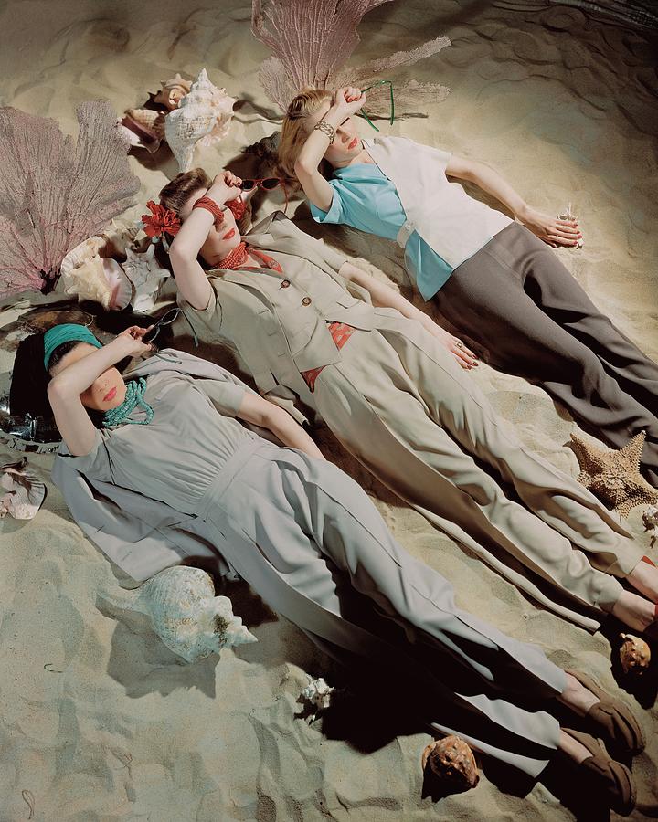 Three Models Lying Down On Sand Photograph by John Rawlings
