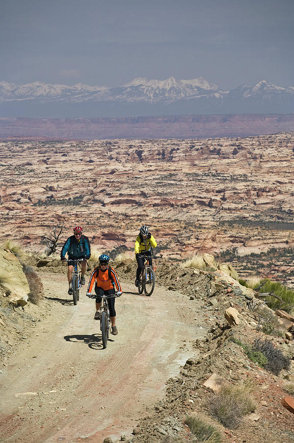 Canyonlands National Park Photograph - Three People Mountain Biking On Dirt by Whit Richardson
