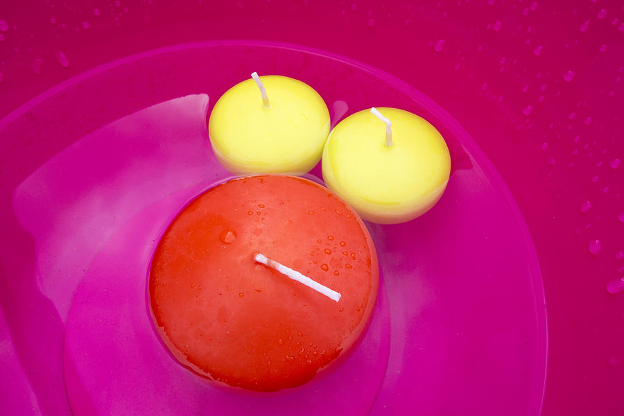 Three red and yellow candles in pink bowl colorful and vibrant Photograph by Matthias Hauser