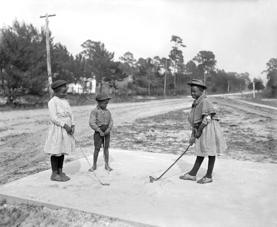 Black And White Photograph - Three Young Children Play Golf by Underwood Archives