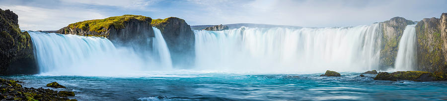 Thundering waterfalls cascading into blue mountain river panorama Godafoss Iceland Photograph by fotoVoyager