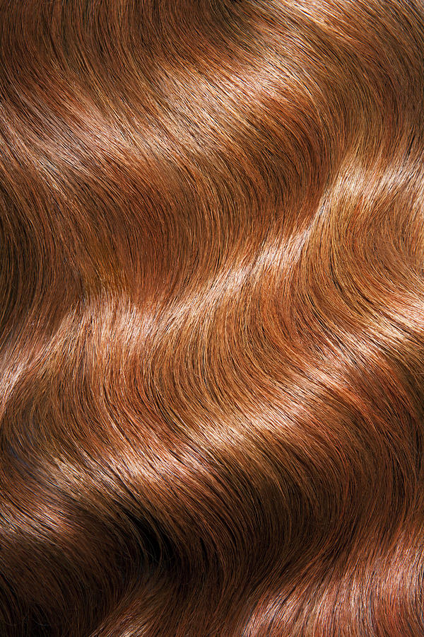 Tight shot of wavy, shiny red hair. Photograph by Andreas Kuehn