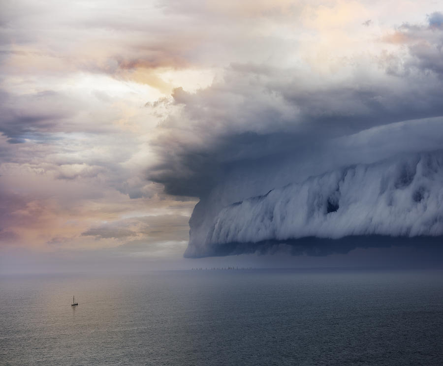 Tiny sailing boat and incoming storm Photograph by Olaser