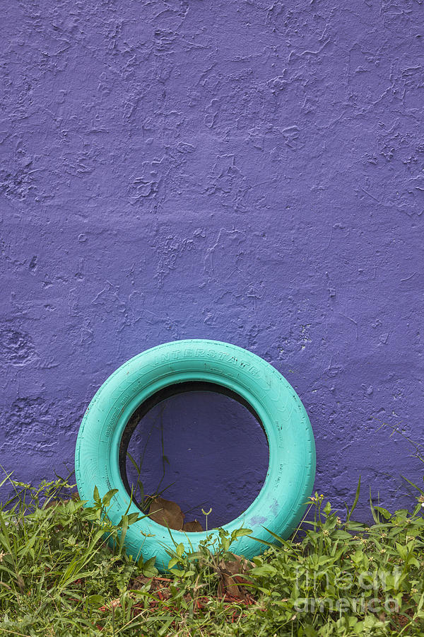 Tire Painted In Bright Color Leaning Against Wall in San Juan Pue Photograph by Bryan Mullennix