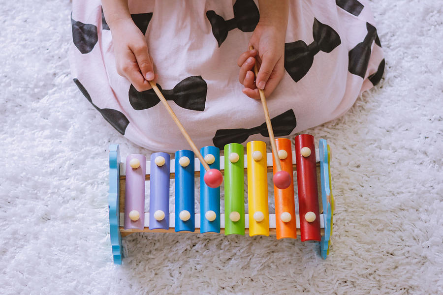 Toddler playing a xylophone at home Photograph by Suphat Bhandharangsri Photography