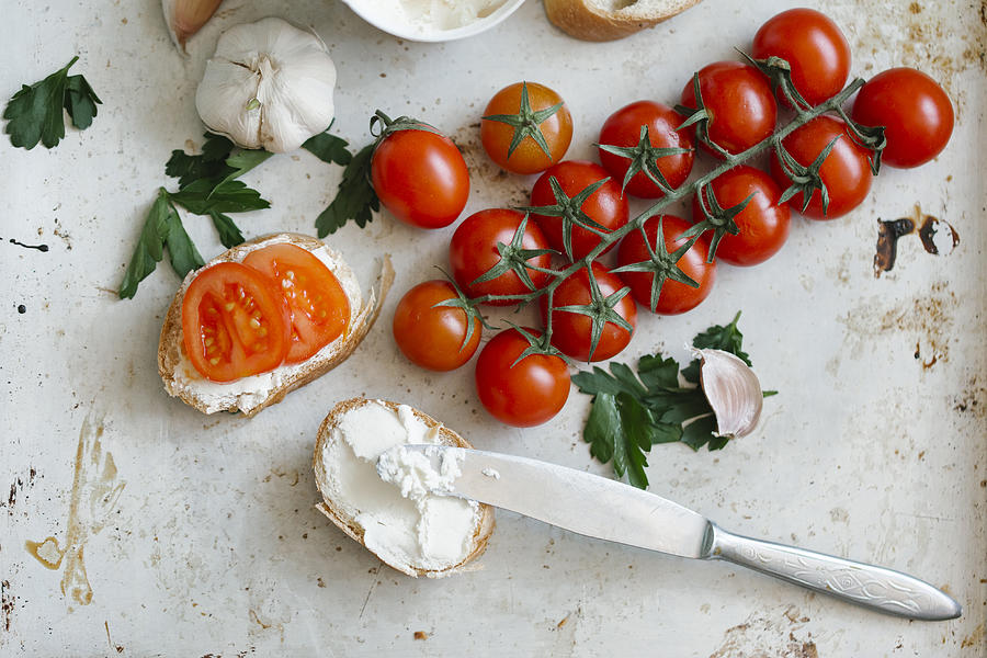 Tomatoes on vine near cream cheese and bread Photograph by Aleksandr Kuzmin