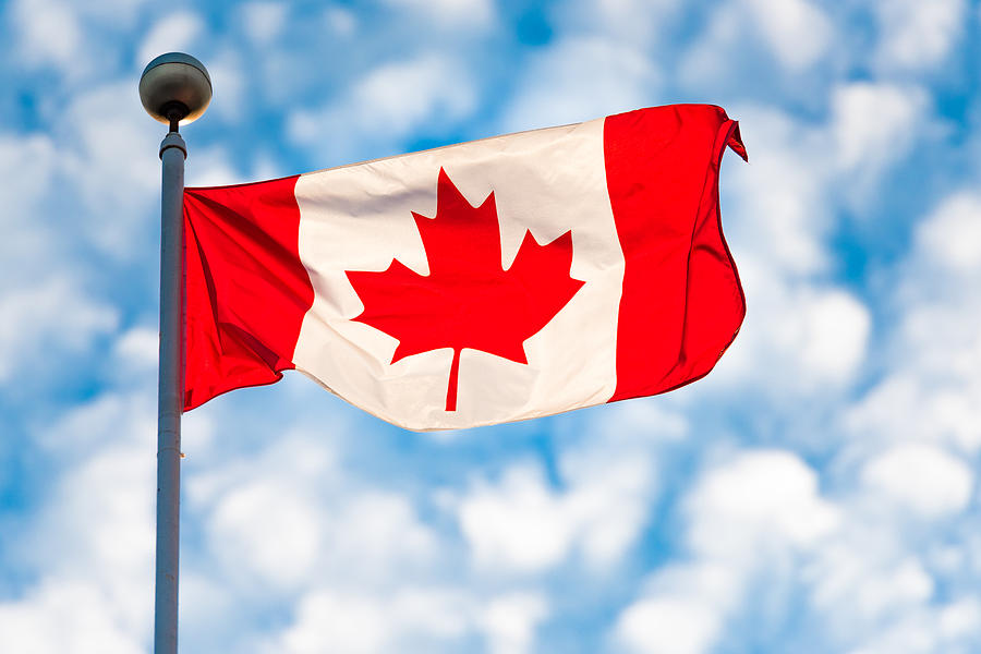 Toronto,Canada: Canadian National Flag Waving on a partially cloudy sky Photograph by Manoa