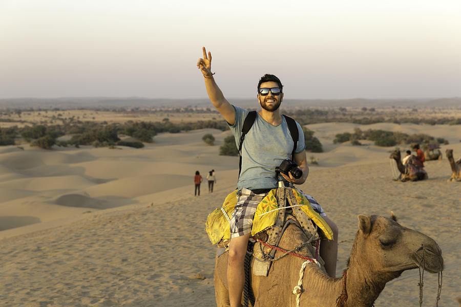 Tourist riding camel in Desert Photograph by FG Trade