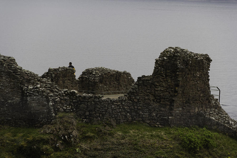 Tourist visible at the battered remains of the Urquhart Castle Photograph by Ashish Agarwal