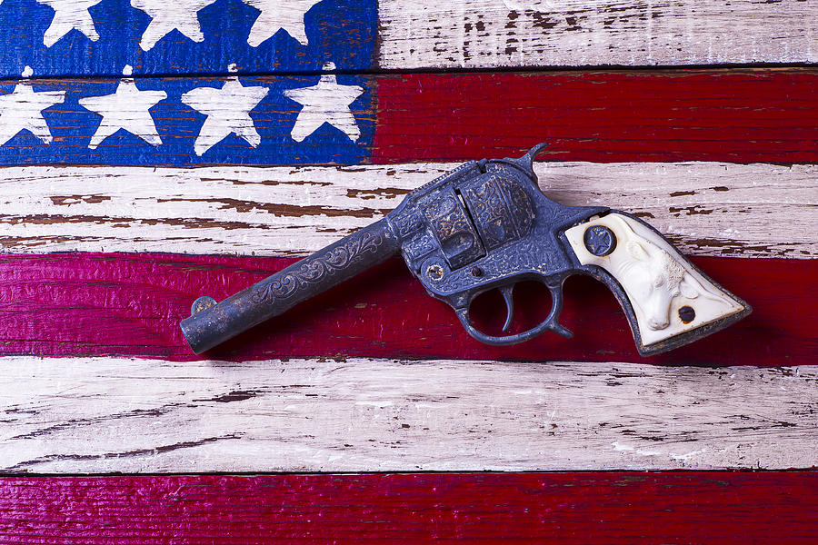 Toy Gun On Wooden Flag Photograph by Garry Gay