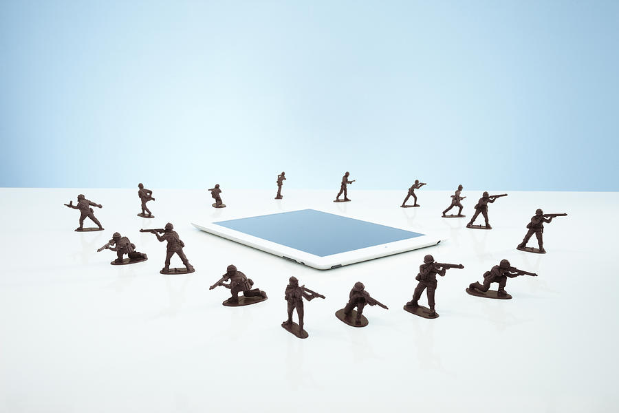 Toy soldiers in a firewall around tablet Photograph by Richard Drury