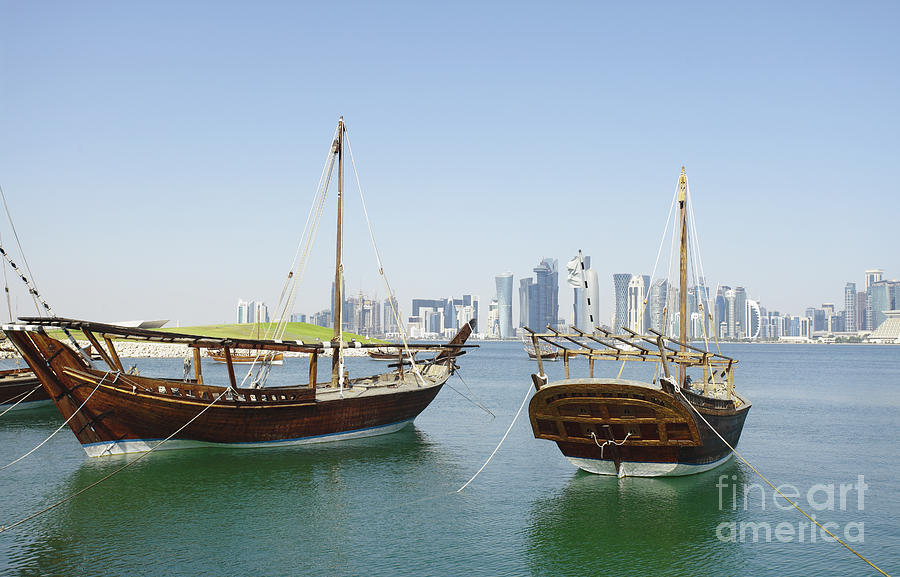 Traditional wooden dhows and Doha skyline Photograph by Paul Cowan