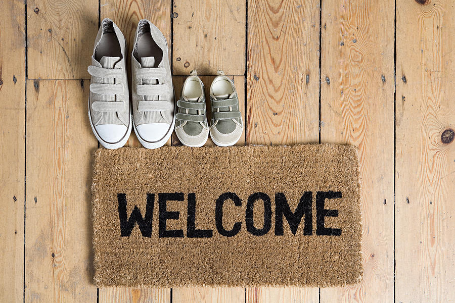 Training shoes and a welcome mat Photograph by Image Source