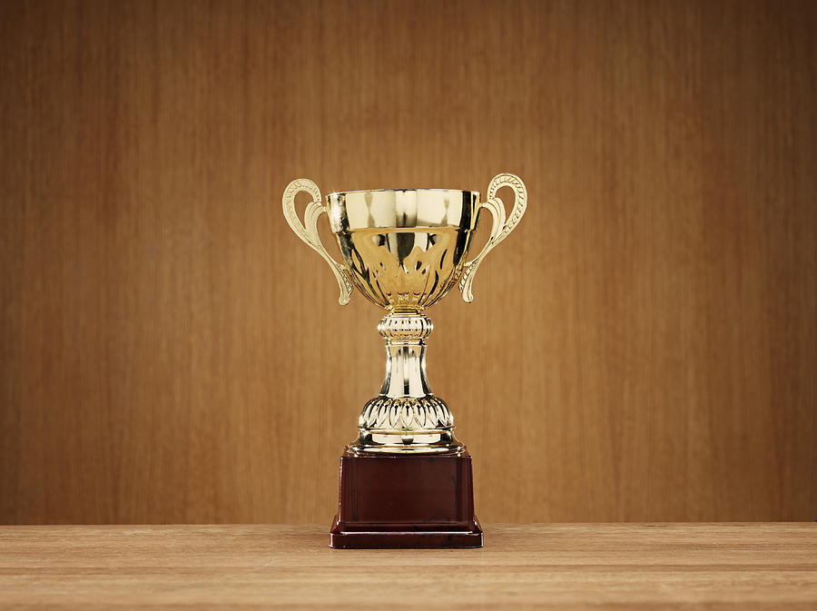 Trophy on wooden background Photograph by Johner Images