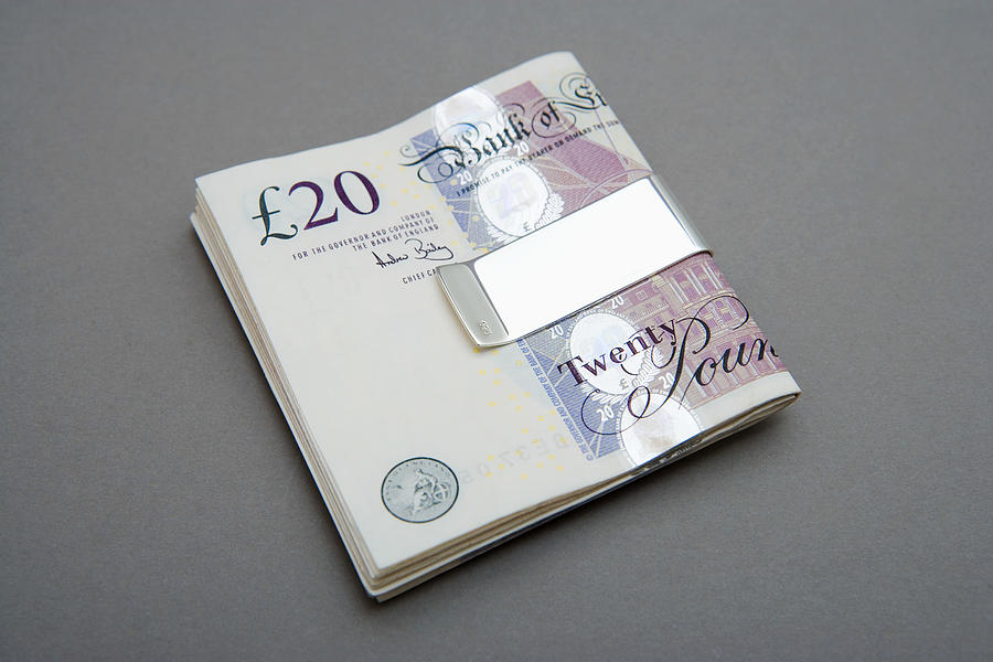 Twenty pound notes in money clip Photograph by Image Source