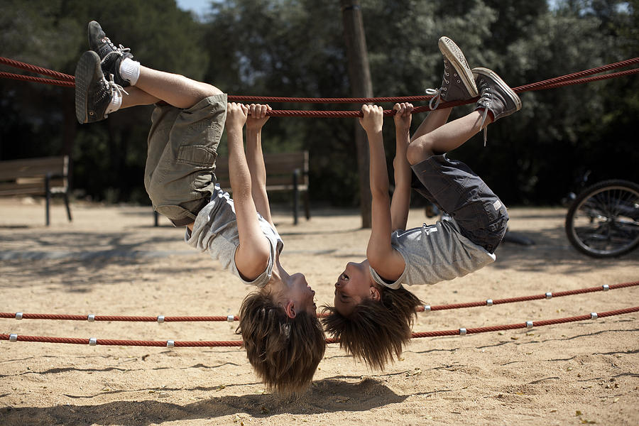 Twins Hang From Structure In Park Photograph by Photo and Co