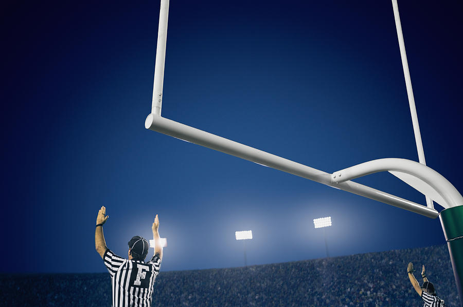 Two American football referees giving touchdown signal, rear view Photograph by David Madison