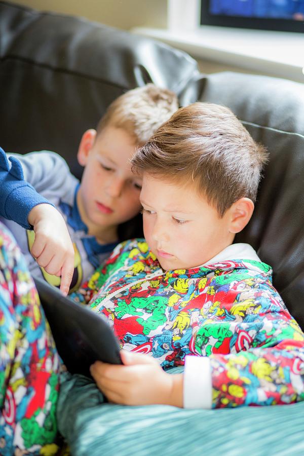 Two Boys Using A Digital Tablet Photograph by Samuel Ashfield
