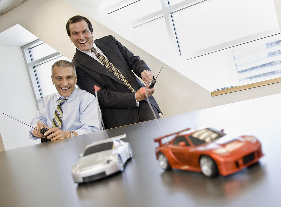 Two business men playing with remote control cars Photograph by Andersen Ross