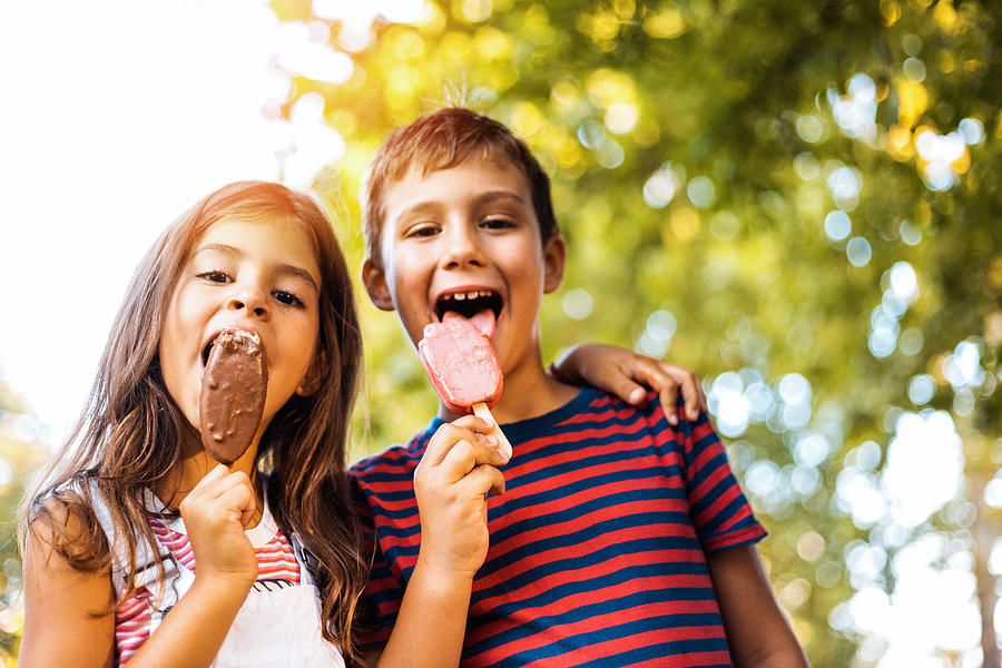 Two children eating popsicle Photograph by Obradovic