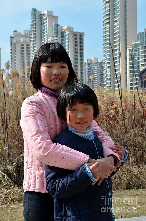 Two Chinese teen sisters hug  and embrace Shanghai China Photograph by Imran Ahmed