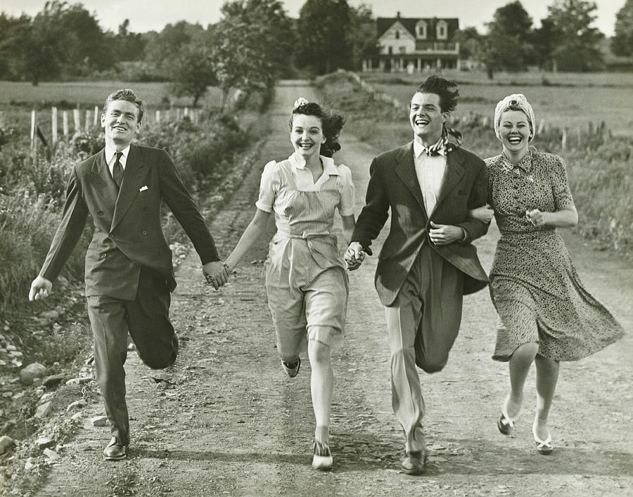 Two couples holding hands, running on footpath, (B&W) Photograph by George Marks