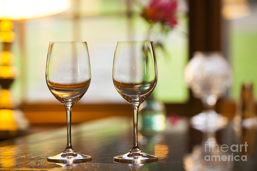 Two empty wine glasses on a bar. Photograph by Don Landwehrle