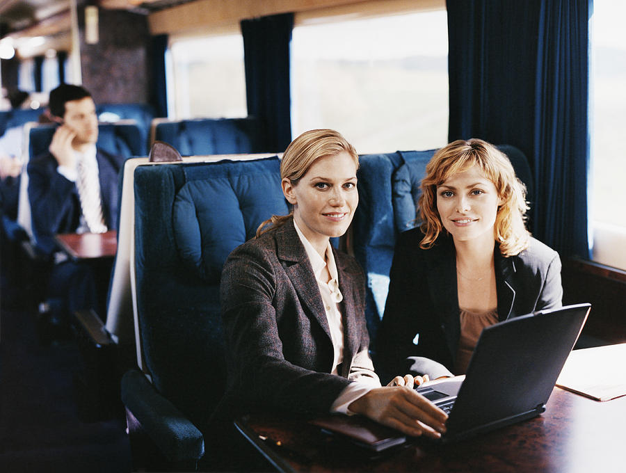 Two Female Business Executives With a Laptop on a Passenger Train Photograph by Digital Vision.
